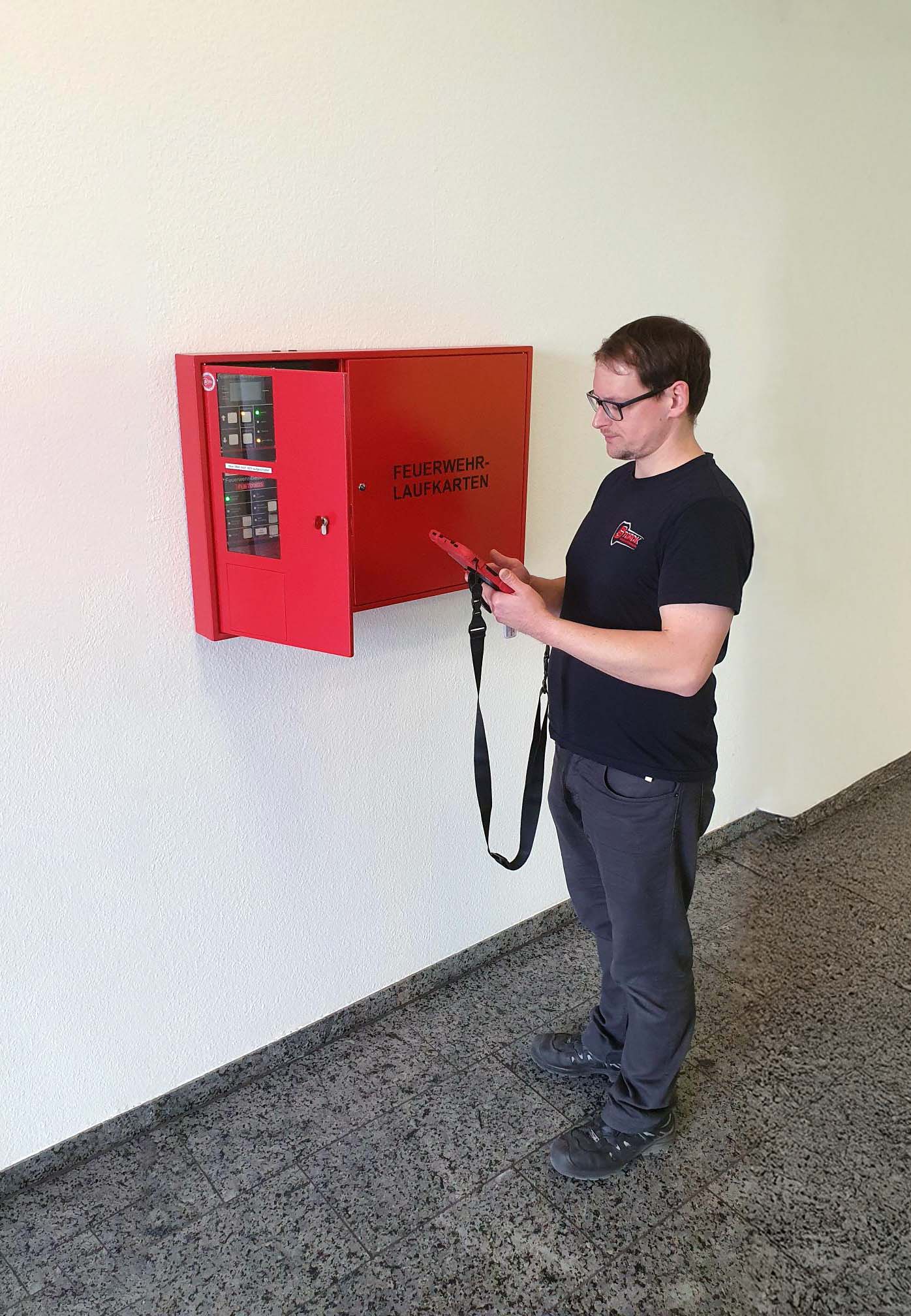 Ein Mann prüft Brandmelder am Feuerwehrinformationszentrum