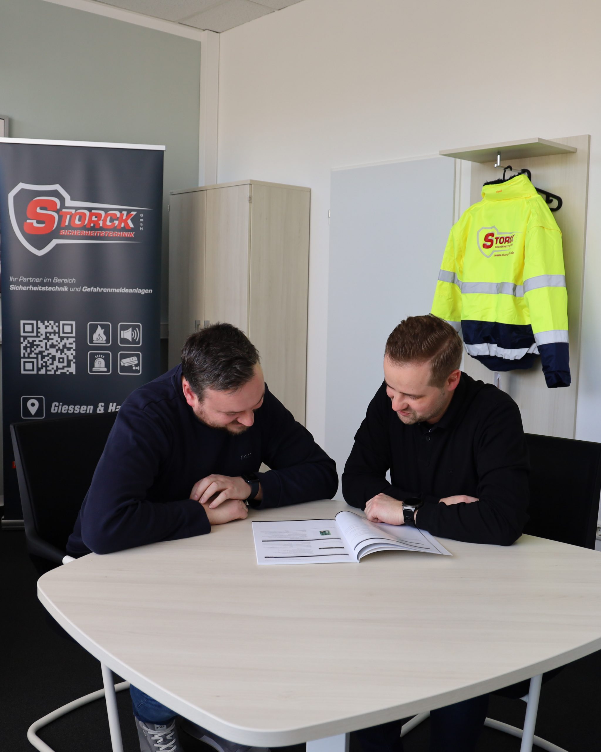 Mitarbeiter im Büro lesen eine Broschüre